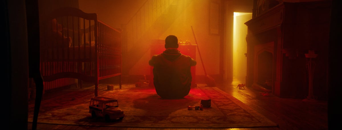 A man sitting on the floor is engulfed in haze created by Rosco V-Hazer.