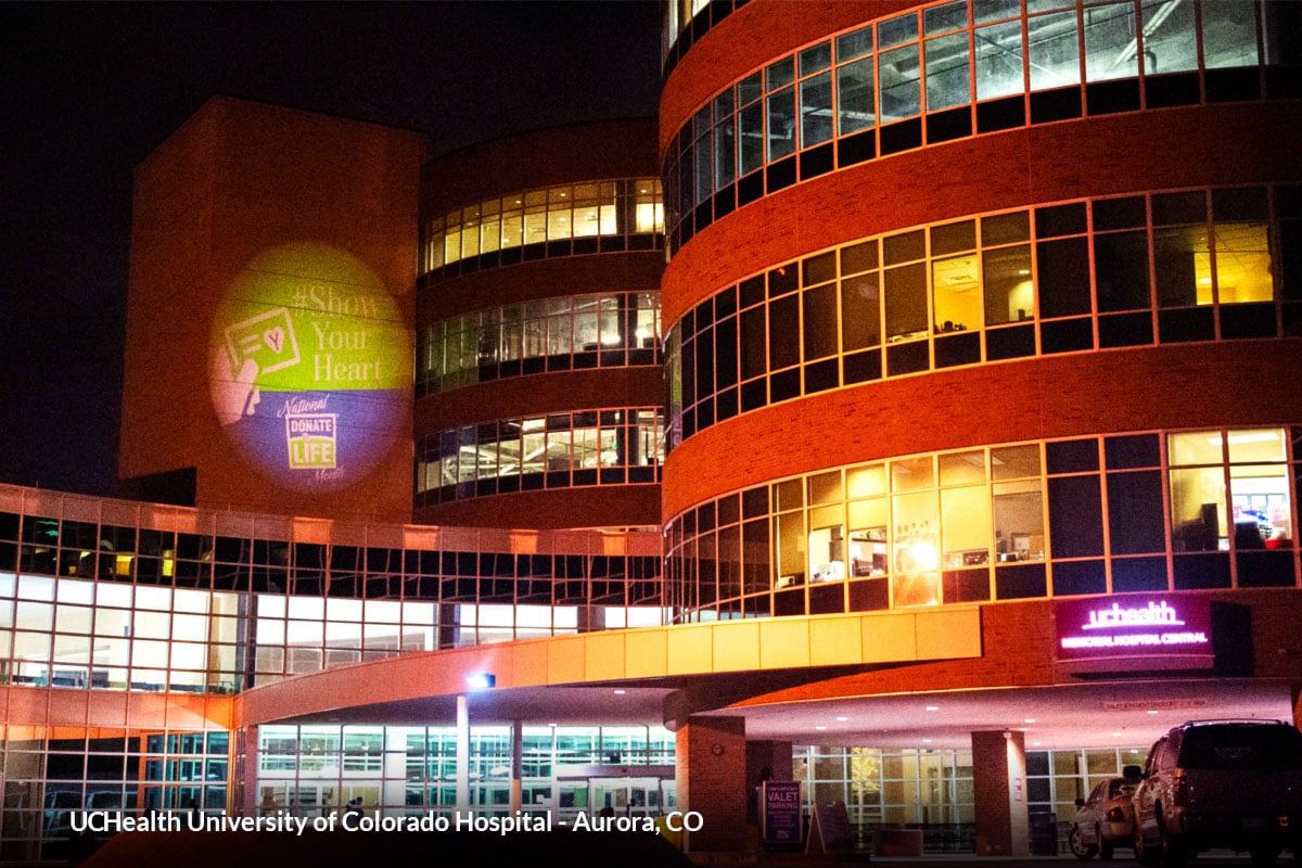 A hospital in Aurora, Colorado projects a "Show Your Heart" logo onto its facade.
