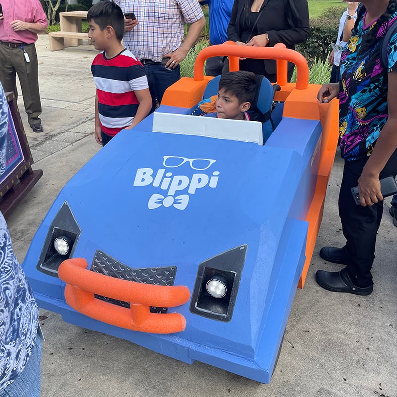 A Blippi Car adaptive costume for children with disabilities.