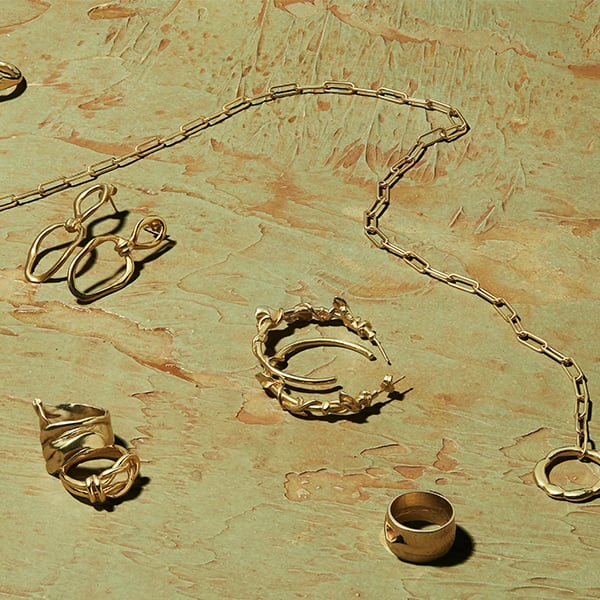 Jewelry on a marbled textured photography backdrop that was painted with Rosco Supersat Paints.